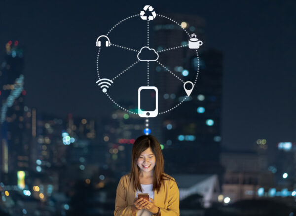 Asian businesswoman using smart mobile phone with smile action for operate various icon